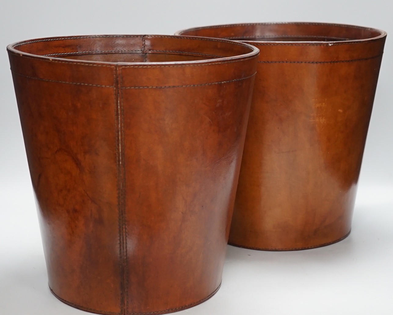 Two brown leather waste paper bins, 30cms high